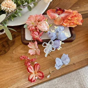 Vista dettagliata di eleganti fermagli per capelli a fiori in tessuto con nappe