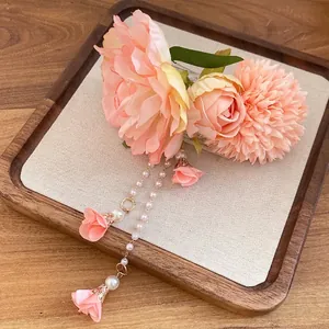 Elegante fermaglio per capelli con fiori in tessuto e nappe di perle, stile romantico.