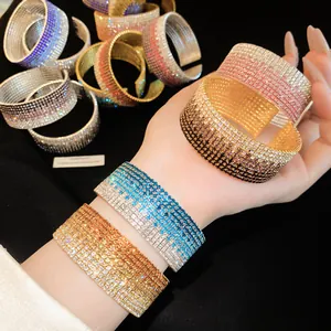 Detailed view of multi-row rhinestone gradient stretch open bracelets on a hand.
