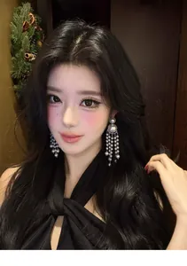 Close-up of model wearing elegant pearl beaded tassel earrings in a festive setting