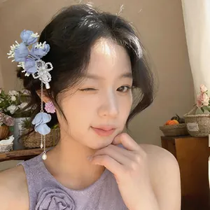 Elegante fermaglio per capelli a fiore in tessuto blu indossato da una modella