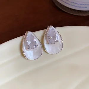Detailed view of elegant silver teardrop earrings featuring white enamel and zircon stones