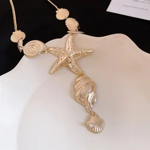 Detail showing golden starfish and seashell pendants with pearl on a necklace