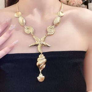 Detailed view of gold starfish and shell pendant necklace on model.