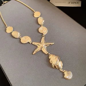 Macro view of a gold starfish and shell pendant necklace featuring a small pearl
