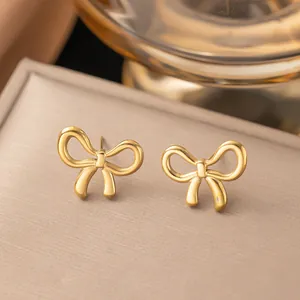 Elegant minimalist gold bow stud earrings with a sleek polished finish for women.