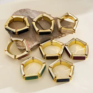 Detailed macro view of chunky gold-toned resin stretch bracelets in various vintage colors