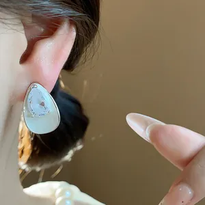 Close-up macro view of teardrop stud earring featuring zircon inlay and white drip oil detail