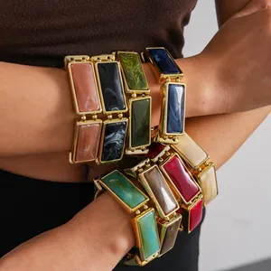 Detailed macro view showing a variety of colorful rectangular resin bracelets stacked on arms
