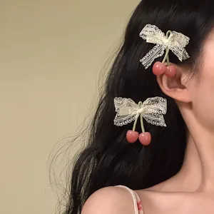 Detailed view of sweet lace bow hair clips featuring cute pink cherry fruit charms