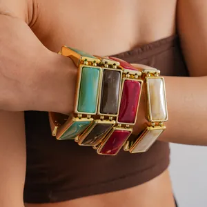 Detailed close-up of retro chunky resin bracelets with gold-tone frames on a model arm