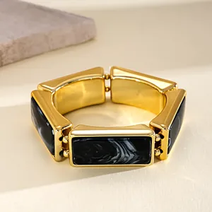 Close-up of vintage resin stretch bracelet with black marble pattern and gold-tone finish.