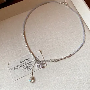 Elegant light blue beaded necklace featuring silver accents and a purple zircon butterfly