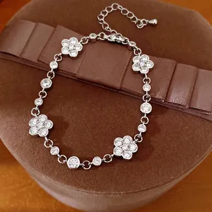 Elegant silver toned flower bracelet with cubic zirconia inlay on a brown jewelry gift box