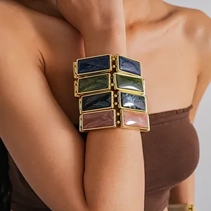 Close-up of chunky rectangular resin link bracelet with marble texture and gold trim