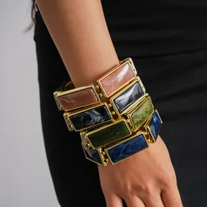 Close-up showing the textures of colorful rectangular resin tiles on a vintage elastic bracelet