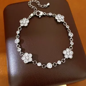 Close-up of elegant silver-colored bracelet featuring zircon-encrusted flower motifs