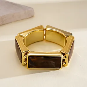 Detail shot showing the polished gold finish and marble resin pattern of this stretch bracelet