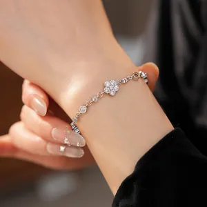 Close-up of a silver flower bracelet with sparkling zirconias on a woman's wrist