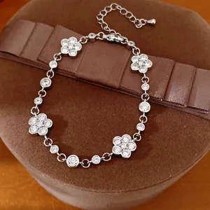 Close-up of silver flower bracelet with sparkling zircons resting on a brown jewelry box