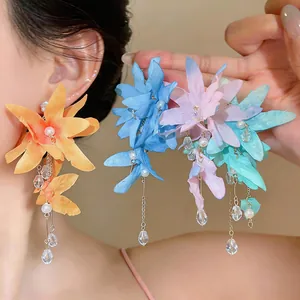 Detailed view of colorful fabric flower tassel earrings with pearls and crystals
