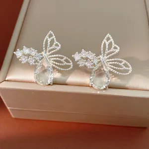 Close-up of butterfly stud earrings with hollow design and pear-shaped zircon stones