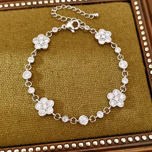 Detailed close-up of a silver flower bracelet with sparkling zircons on green velvet