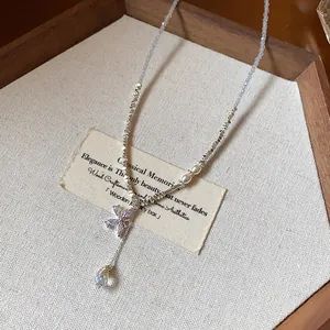 Close-up of butterfly zircon pendant and crushed silver beaded chain necklace