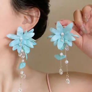 Detailed view of light blue fabric flower earrings with elegant pearl tassels