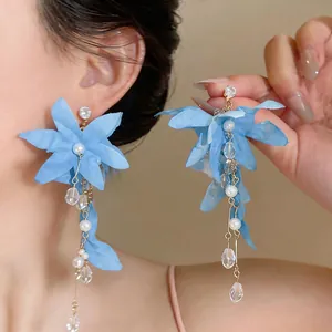 Close-up detail of blue fabric flower tassel earrings with elegant pearls and crystals