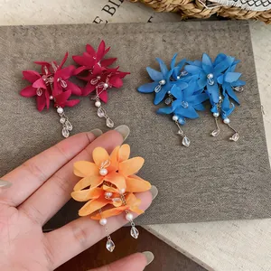 Macro view of handmade fabric flower earrings featuring pearl and zircon tassel details