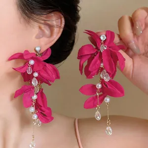 Detail of magenta fabric flower earrings with pearl tassels and zircon accents