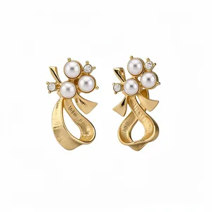 Elegant gold bow stud earrings featuring white pearls and sparkling mini crystals