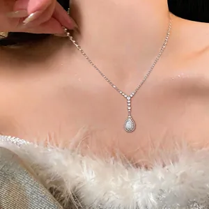 Minimalist silver teardrop pendant necklace with sparkling cubic zirconia on a model.