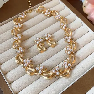 Elegant gold ribbon jewelry set with pearls and crystals in a velvet display tray