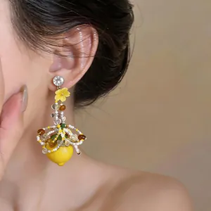 Elegant handmade floral tassel earrings featuring a vibrant lemon pendant for vacation style