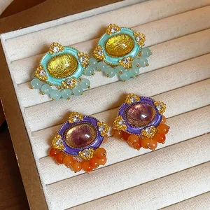 Detailed macro view of vintage resin oval stud earrings with colorful beads and rhinestones