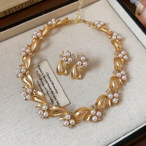 Detailed view of luxury golden bow jewelry set featuring elegant pearls and crystals