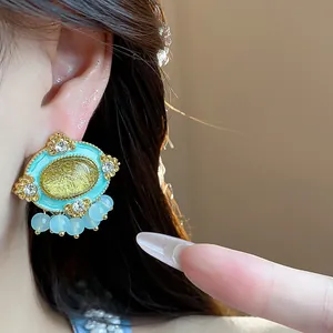 Macro view of vintage oval stud earring with turquoise enamel and light blue beads