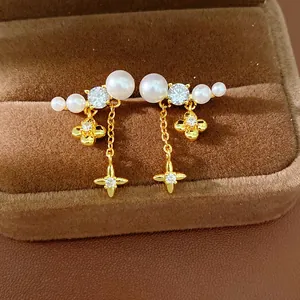 Eleganti orecchini placcati in oro con perle bianche e pietre di zirconi e stelle dorate