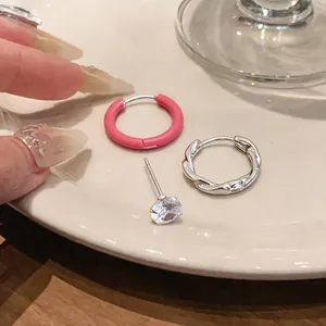 Primo piano di orecchini in argento con smalto, cerchio a spirale e perno in zircone.