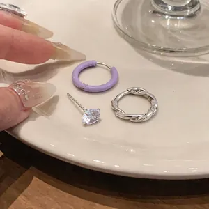 Dettaglio di cerchio in smalto viola, orecchino a spirale e perno in zircone lucido