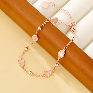Close-up van roségouden enkelbandje met roze kalebasstenen op een sieradendisplay
