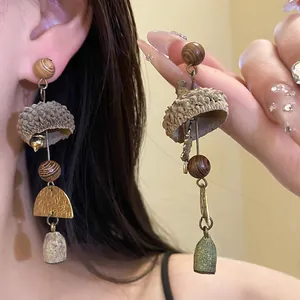 Close-up of vintage forest-style long earrings with eucalyptus fruit and wooden beads