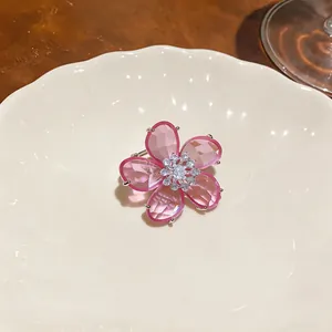 Nahaufnahme eines rosa Zirkon-Blumen-Ohrclips mit funkelnden Kristallblüten