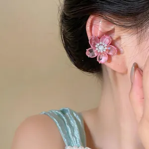 Detaillierte Ansicht eines süßen rosa Zirkon-Blumen-Ohrclips am Ohrknochen des Models.