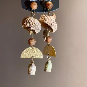 Detailed macro shot of vintage forest-style long earrings featuring natural eucalyptus nuts