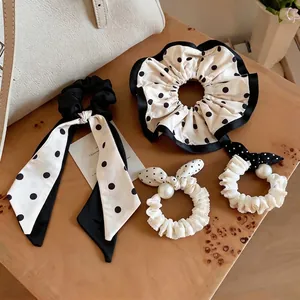 Set of polka dot fabric scrunchies with pearls and ribbon bows on a wooden surface