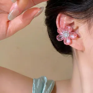 Detailaufnahme eines rosa Kristall-Blumen-Ohrclips mit funkelndem Zirkon-Zentrum