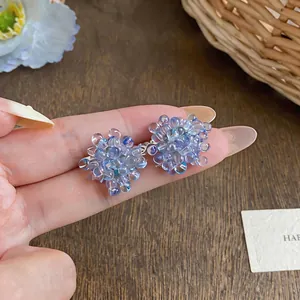 Macro detail of dopamine style glass beaded flower stud earrings with translucent finish